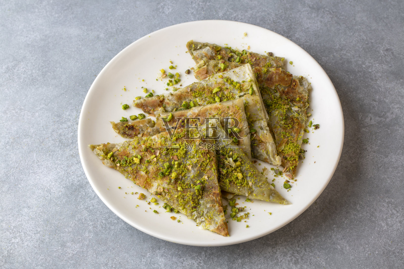 美味的土耳其传统甜点Katmer来自加济安泰普-绿色开心果照片摄影图片