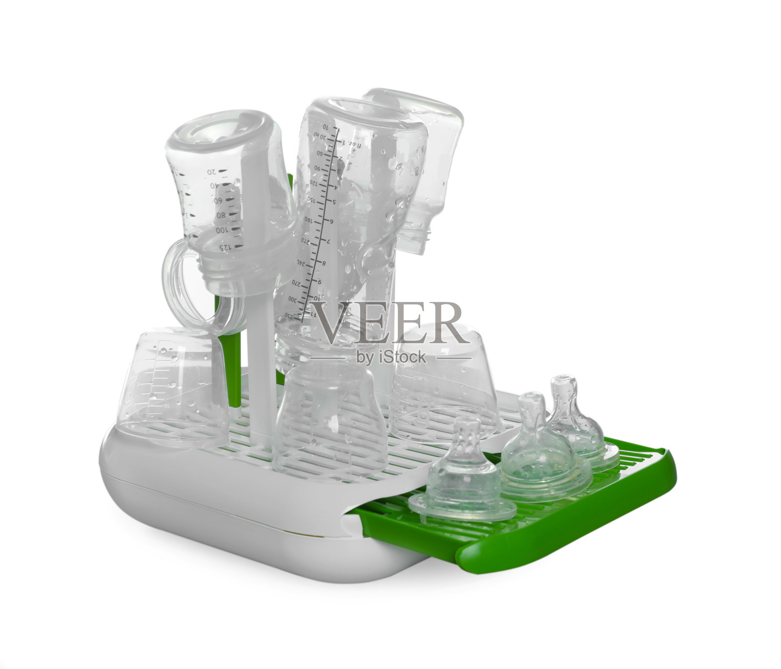 烘干机与婴儿奶瓶和乳头消毒后,在浅灰色的桌子上,白色的背景照片摄影图片