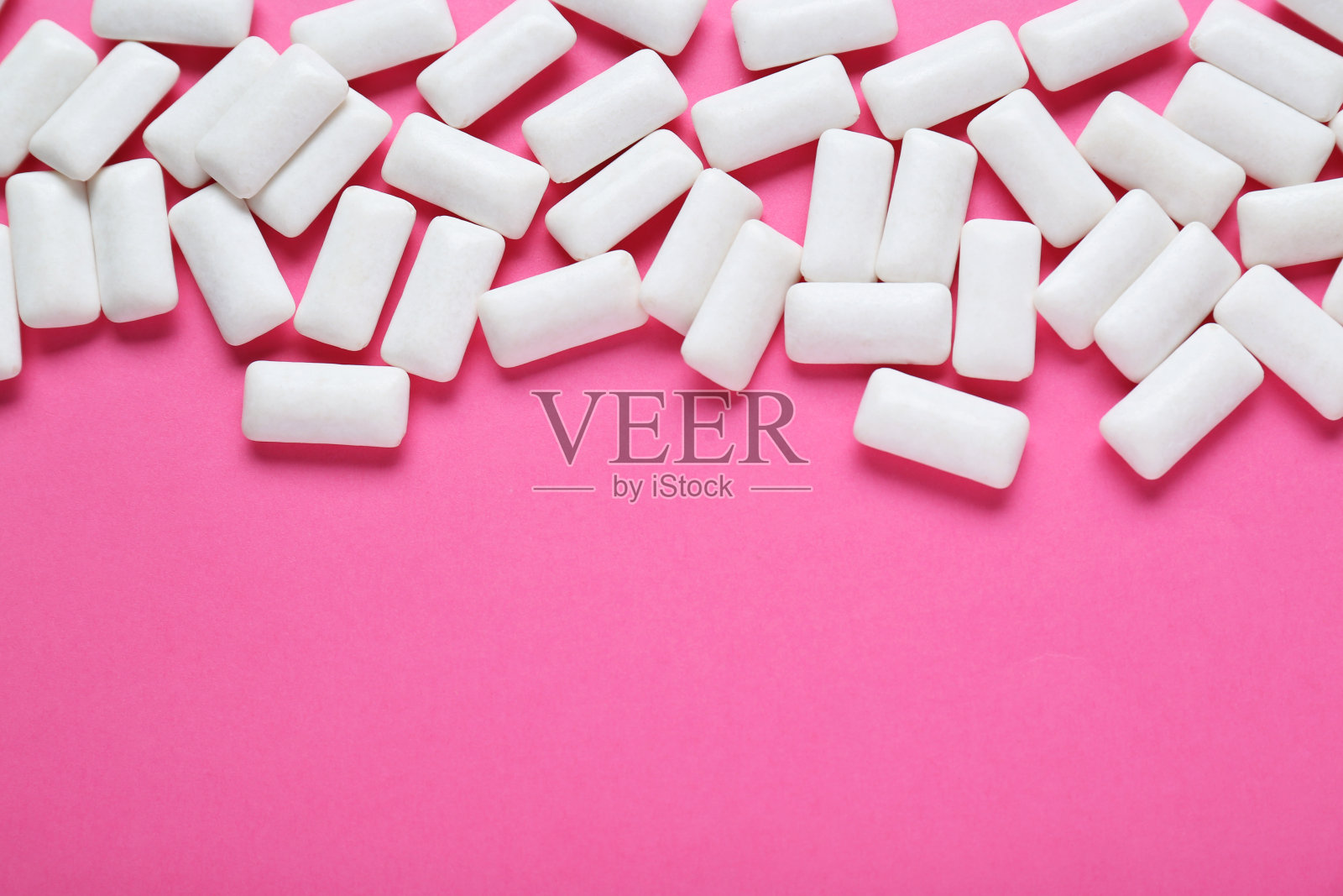 美味的白色口香糖,粉红色的背景,平躺。文本空间照片摄影图片