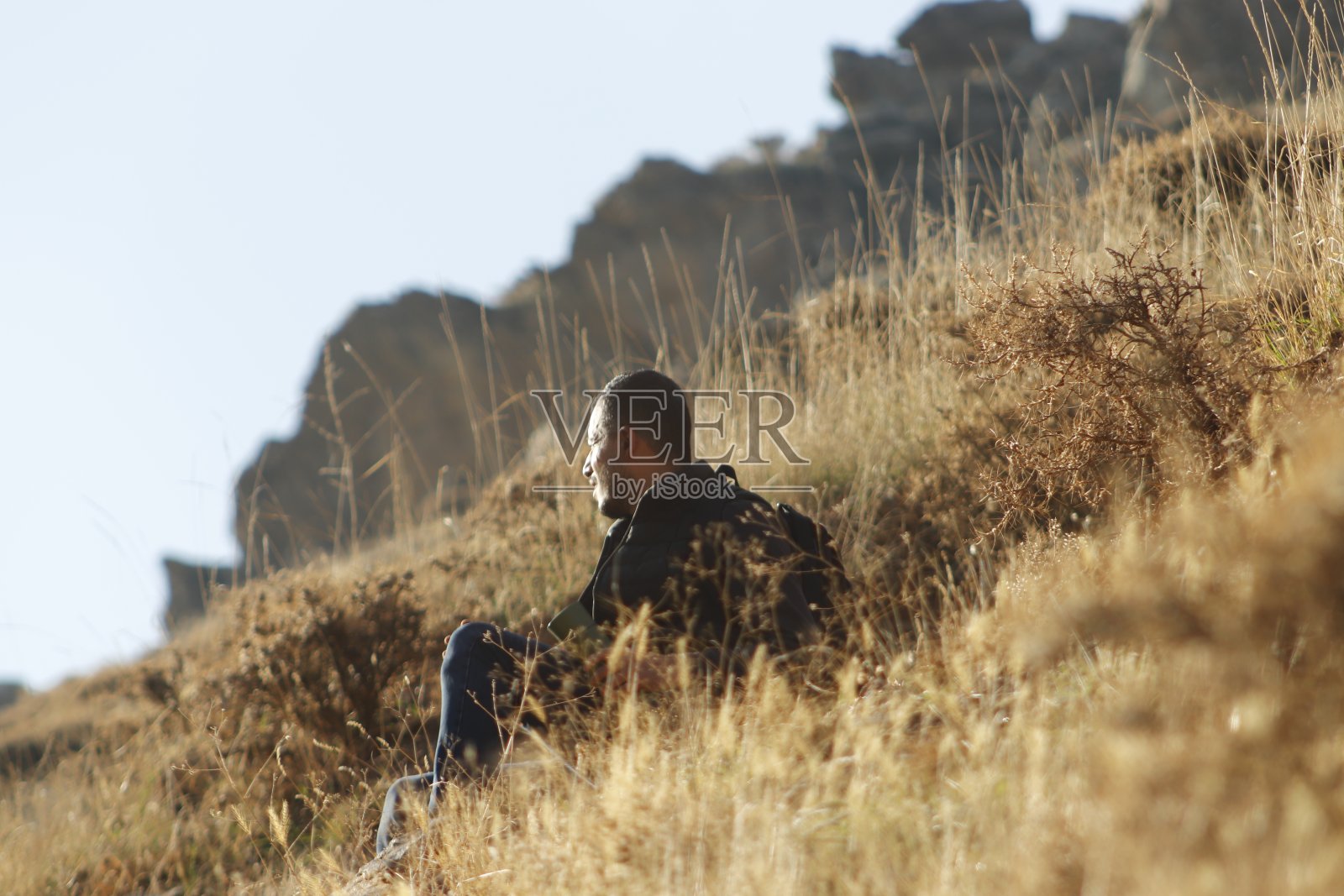 年轻的登山者在岩石间寻找出口照片摄影图片