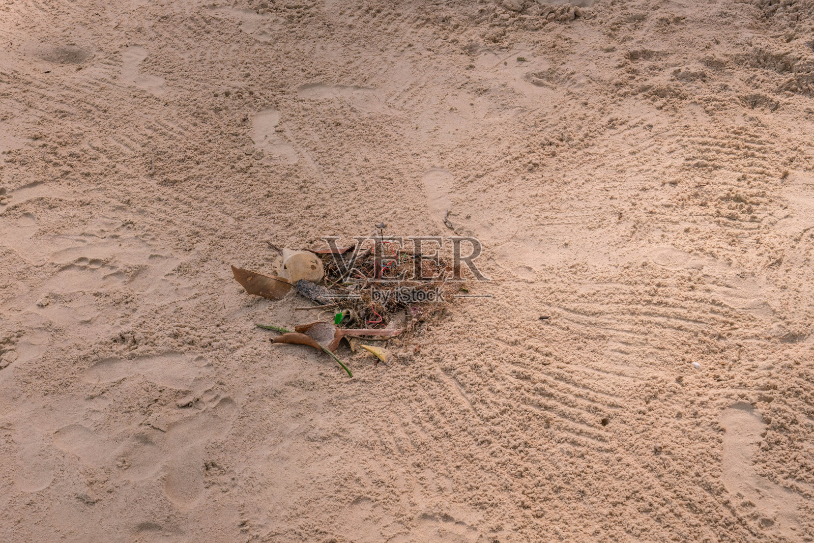 沙滩工人在沙滩上用扫把扫垃圾,特写照片照片摄影图片