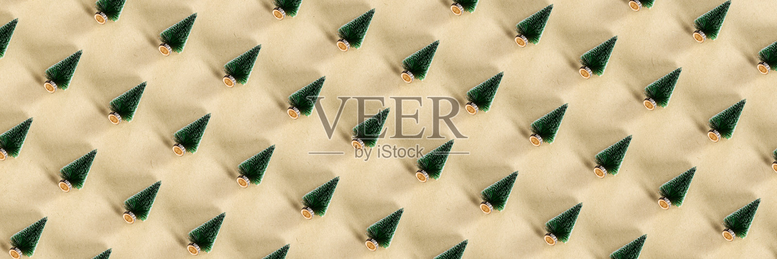 米色背景上的小圣诞树装饰图案。照片摄影图片