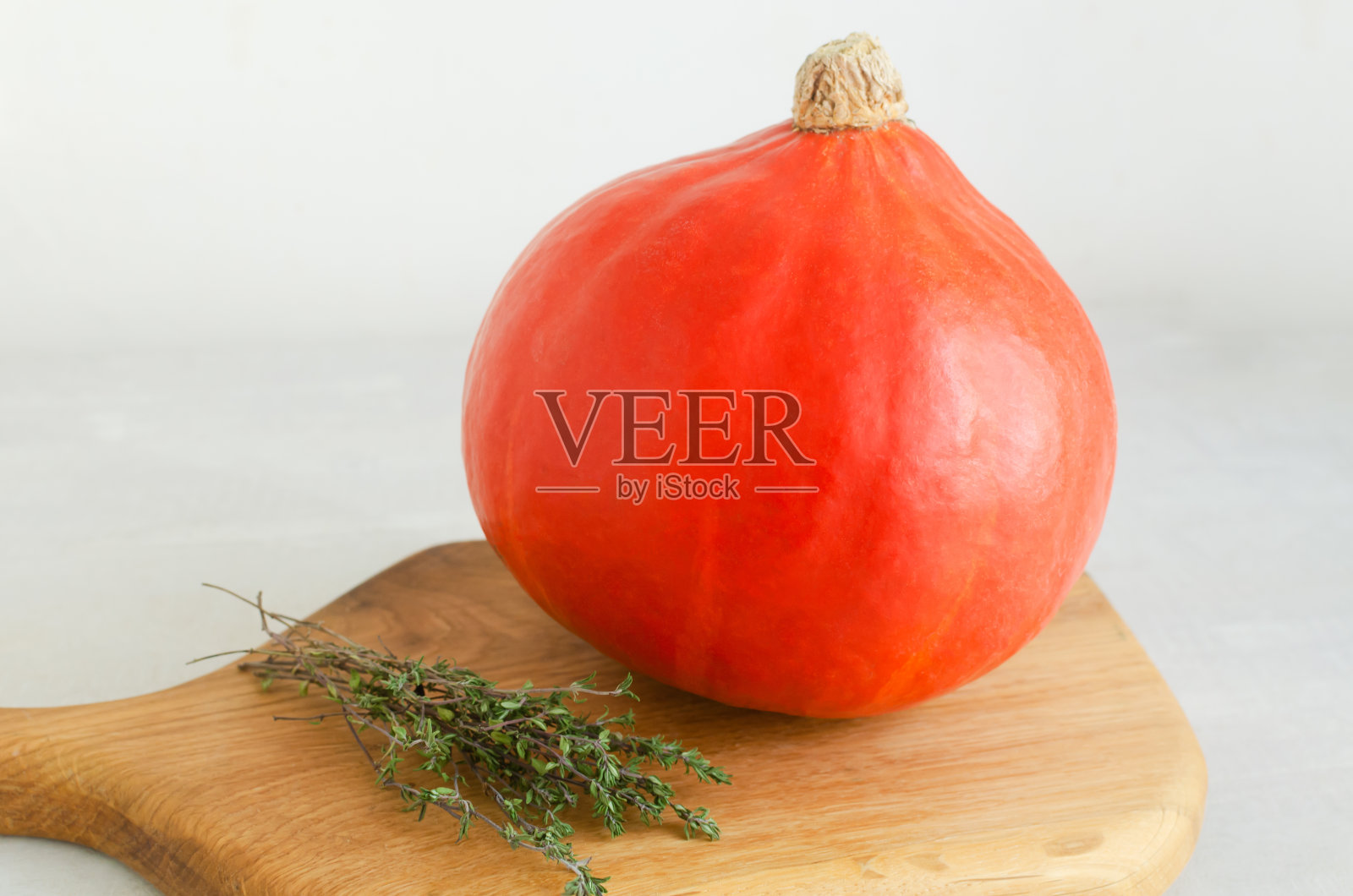 橘色的北海道南瓜和百里香放在砧板上。健康食品的概念。秋天的心情。水平方向。照片摄影图片