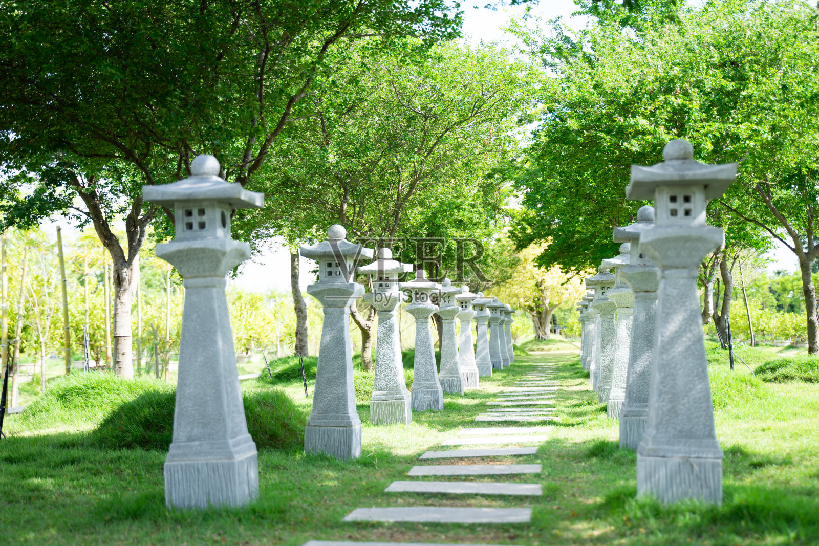 在花园的人行道上,混凝土柱子上的经典路灯排列着照片摄影图片