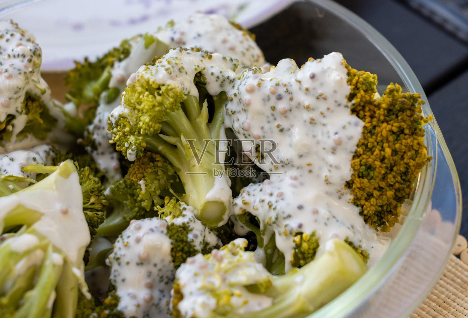 健康的饮食习惯。蒸西兰花,淋上酸奶酱照片摄影图片