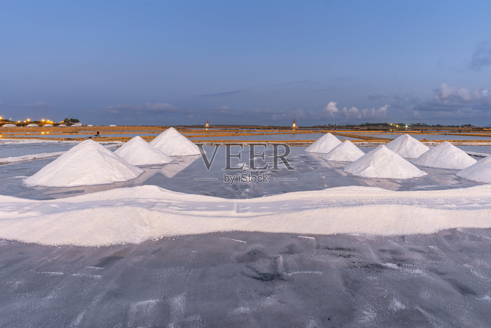 黎明时分在意大利西西里岛的盐滩上收获盐照片摄影图片