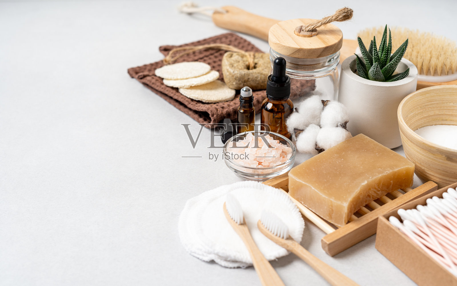 天然浴室和家庭水疗工具。零浪费的可持续生活理念。竹制牙刷、天然香皂、化妆棉、自制DIY美容产品,装在白底可重复使用的瓶子里照片摄影图片
