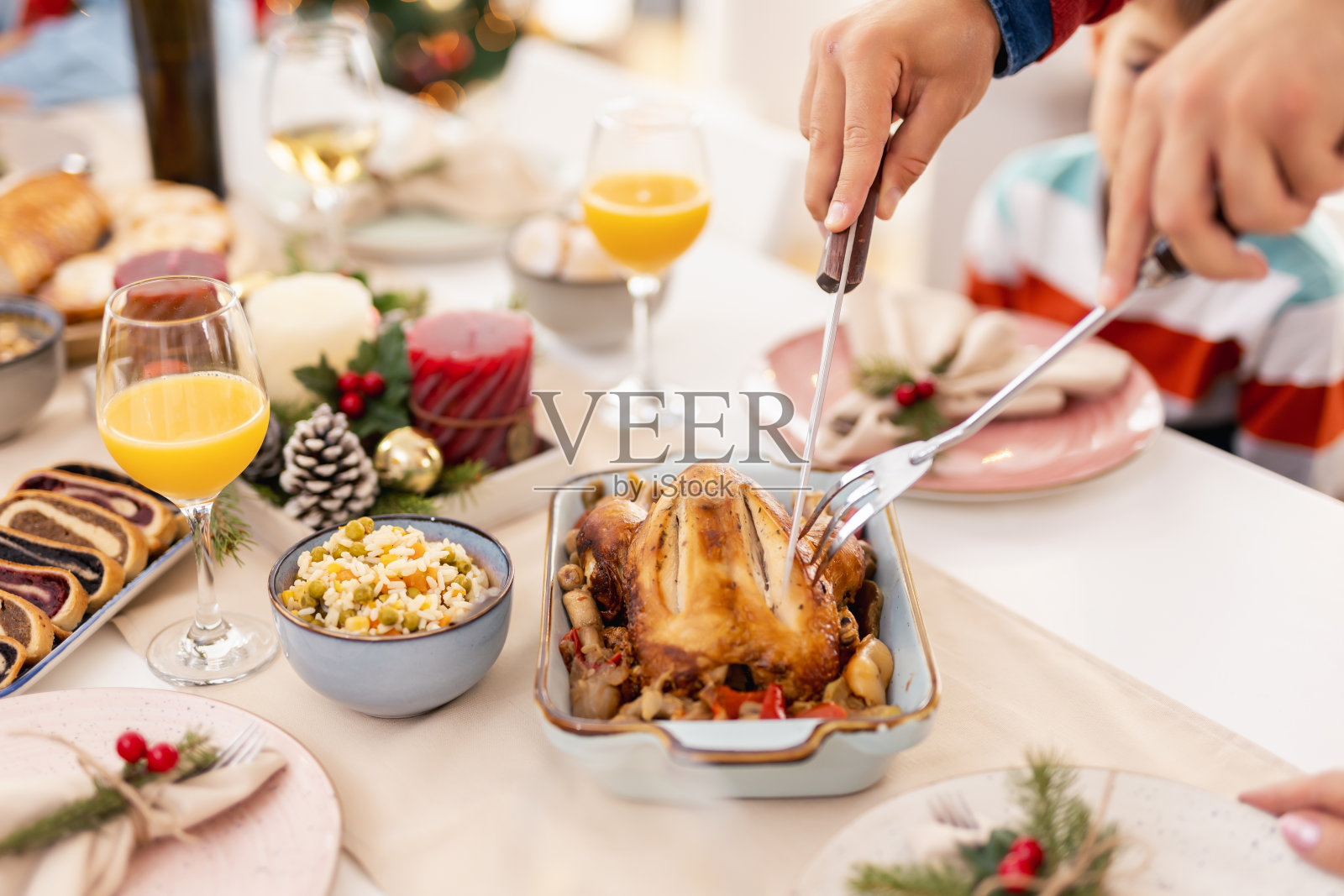 男子为家庭圣诞晚餐切鸡的细节照片摄影图片