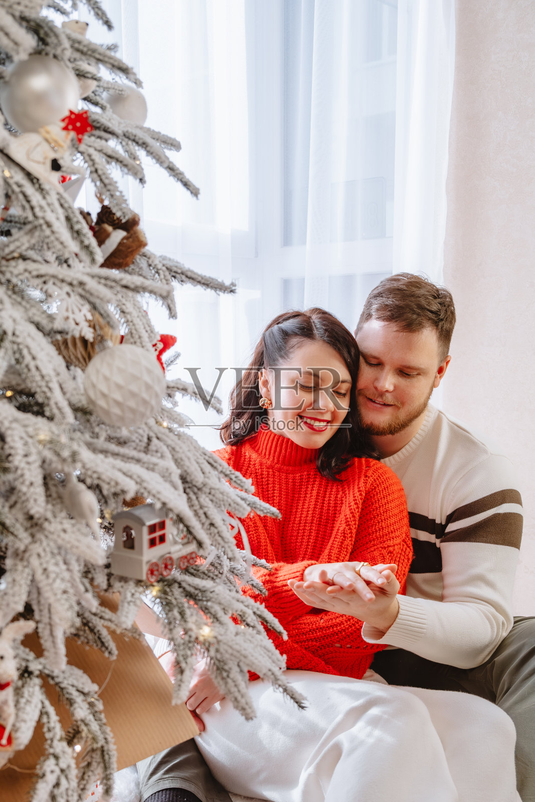 美丽的夫妇在圣诞树旁照片摄影图片