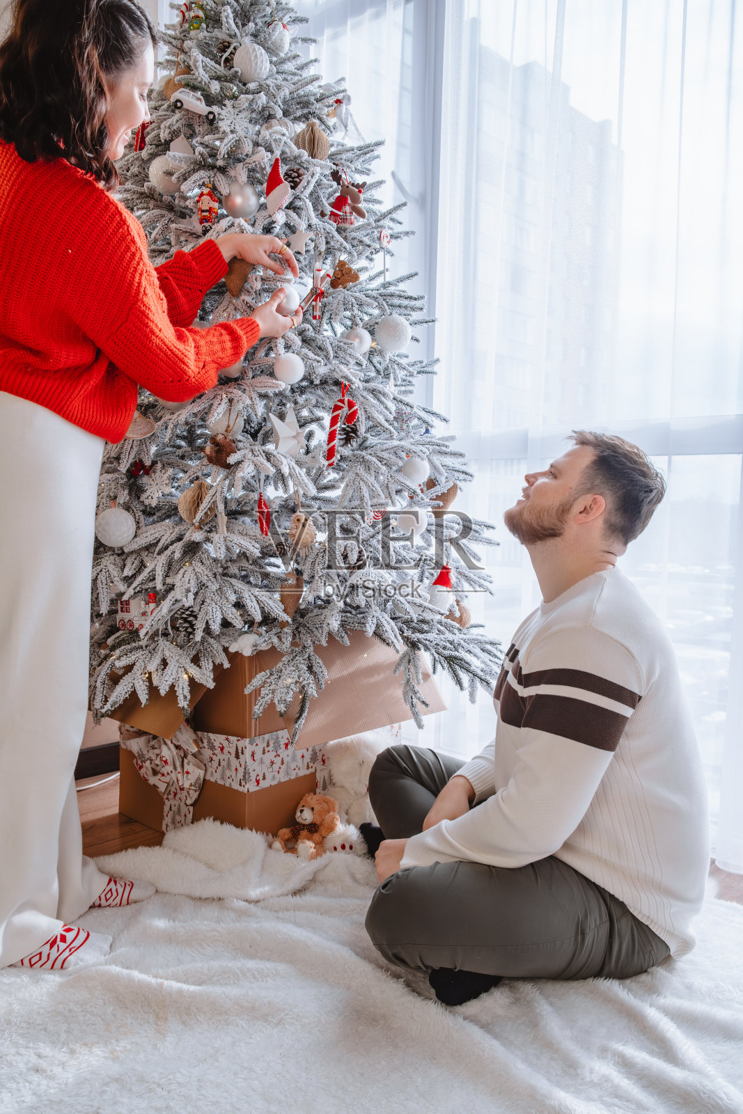 情侣们一起装饰圣诞树照片摄影图片