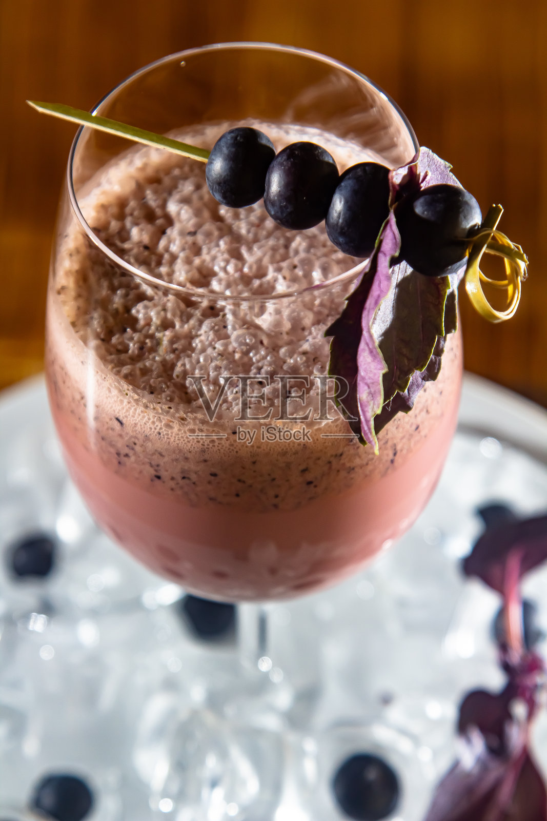 自制的新鲜冰沙,加黑加仑子和蓝莓,装在玻璃杯里,背景上有配料照片摄影图片