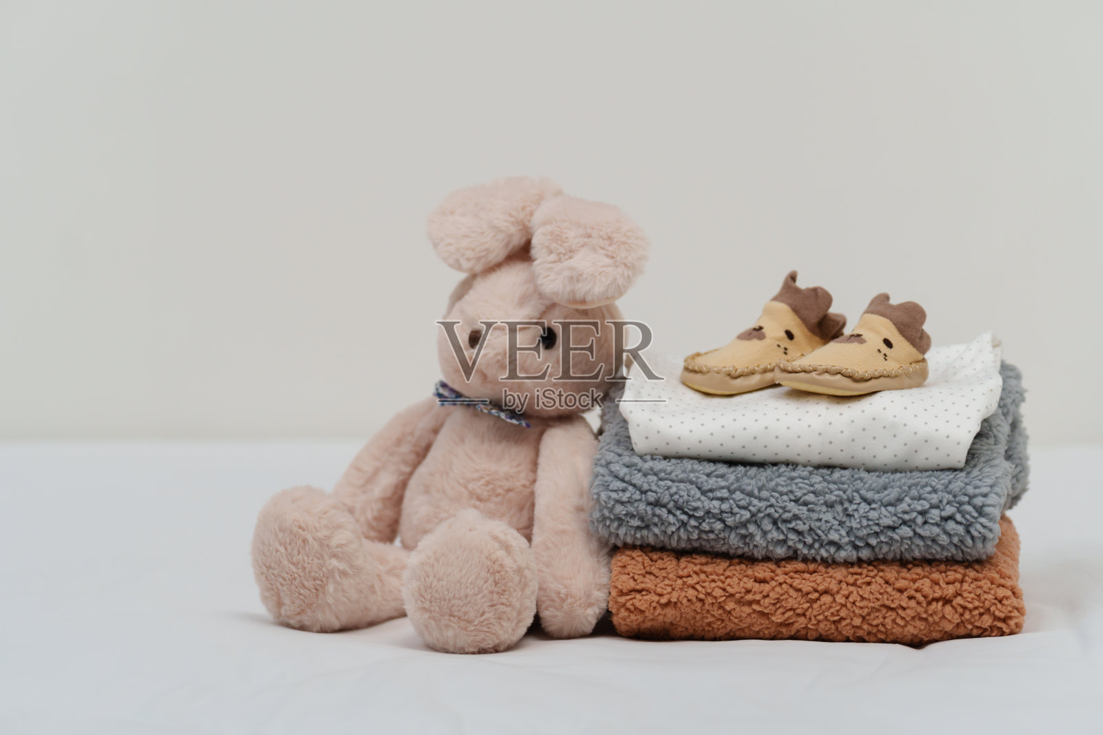 床上堆满了婴儿的衣服、鞋子和玩具照片摄影图片