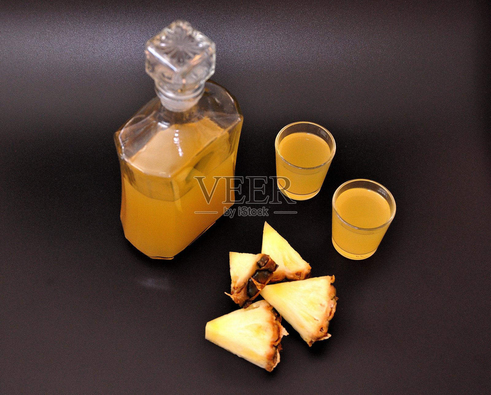 菠萝利口酒和成熟的热带水果在黑色的背景下。照片摄影图片