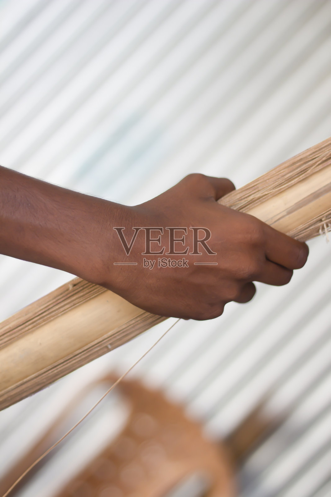 一个男人用手拿着一卷纱线,背景模糊不清照片摄影图片