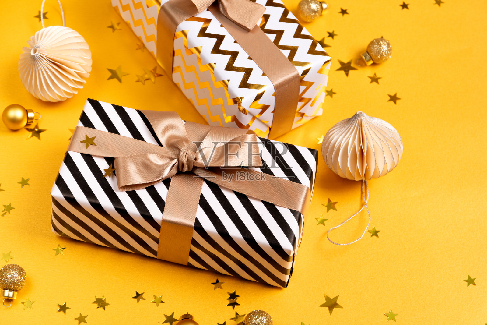 圣诞礼物,礼品盒和节日装饰在黄色背景。圣诞新年背景。照片摄影图片