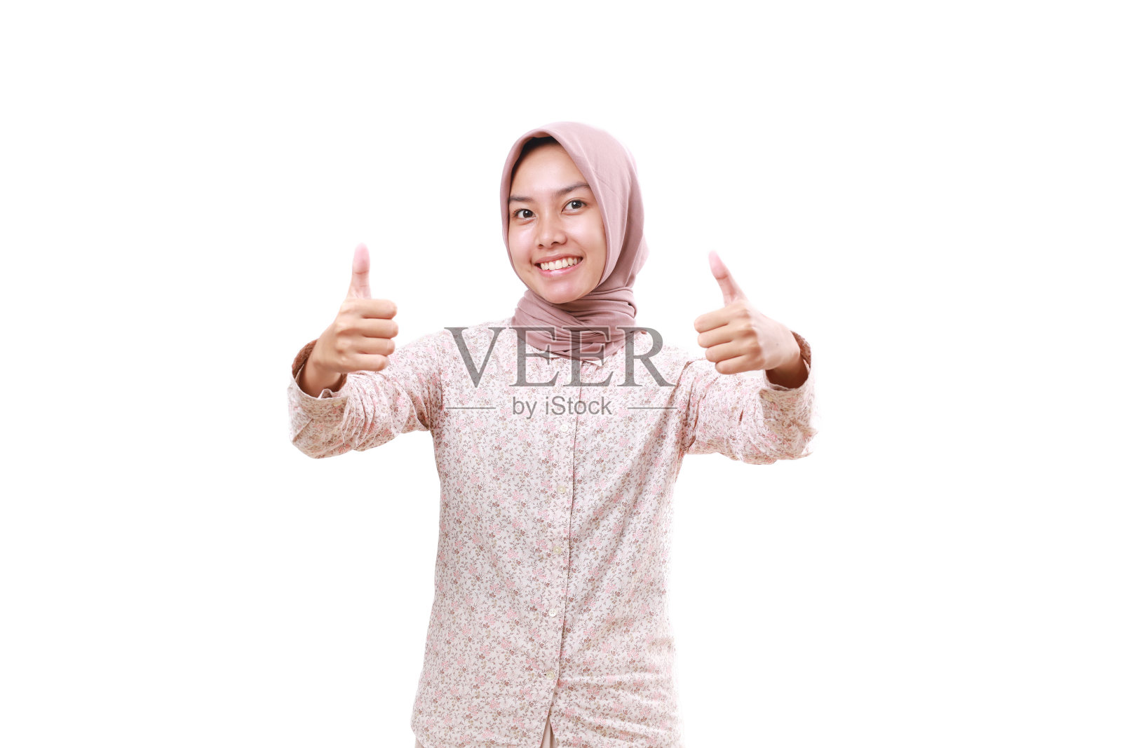 满意的年轻亚洲穆斯林妇女站着竖起大拇指。隔离在白色背景上照片摄影图片