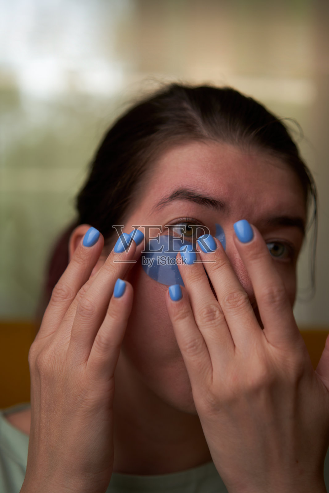 女人正在用化妆贴片敷脸。照片摄影图片