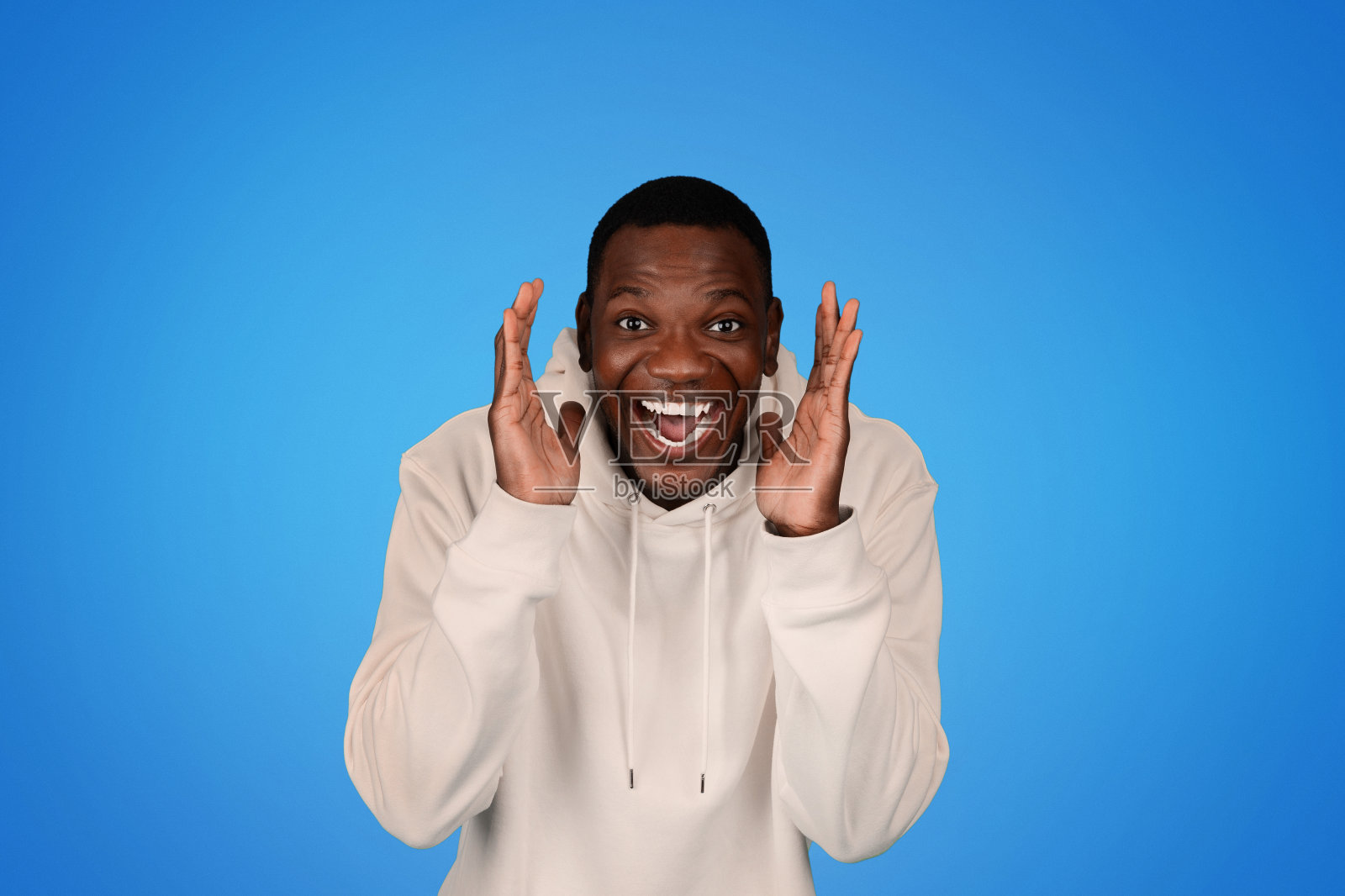 笑着震惊的千禧一代非洲裔美国人穿着卫衣开心地张开嘴照片摄影图片