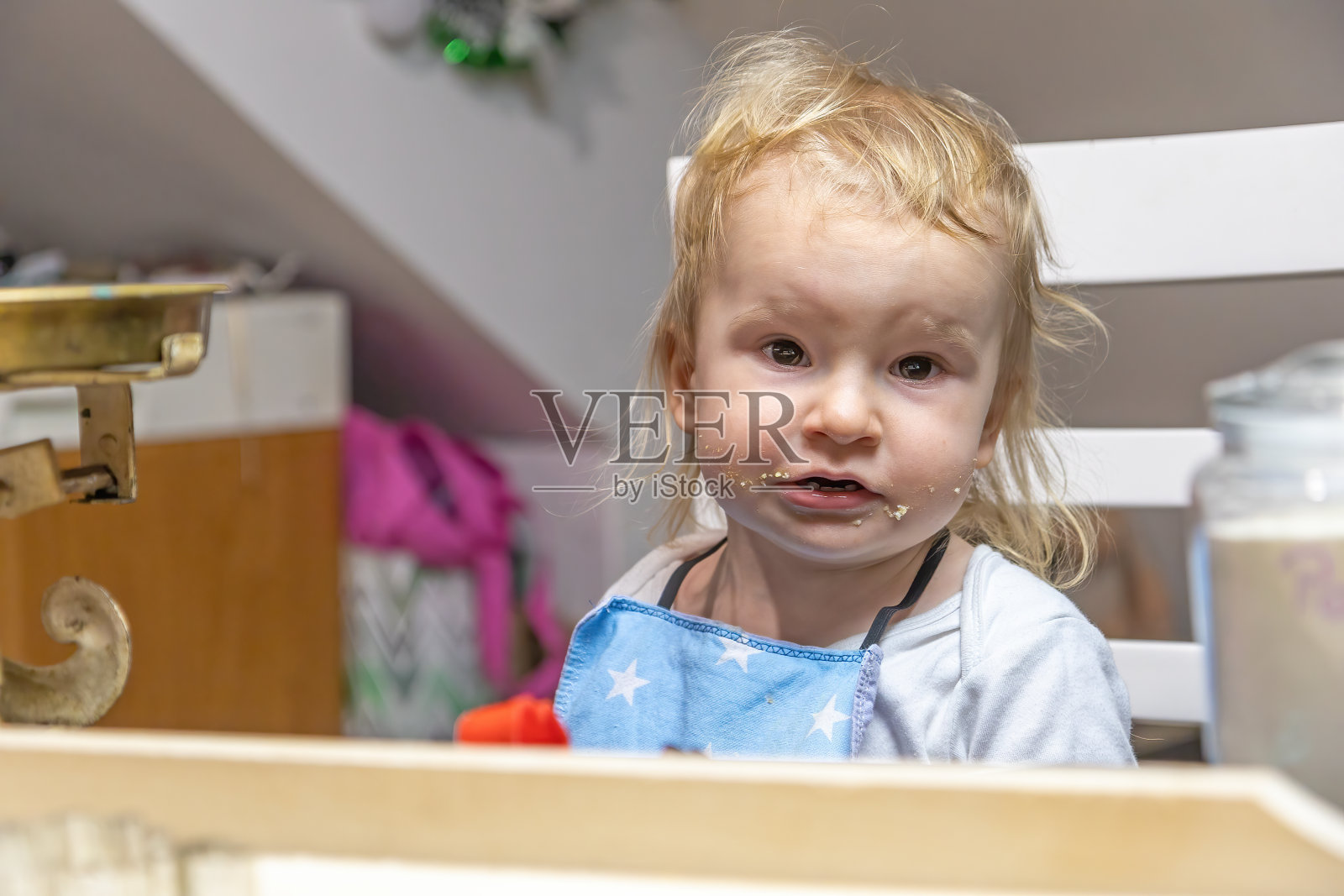 一个可爱的小男孩的肖像,脸上有面团屑。照片摄影图片