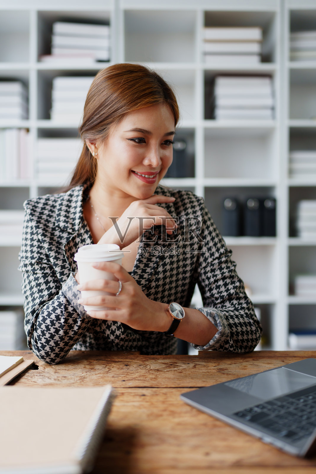 一个女商人一边打电话一边喝咖啡照片摄影图片