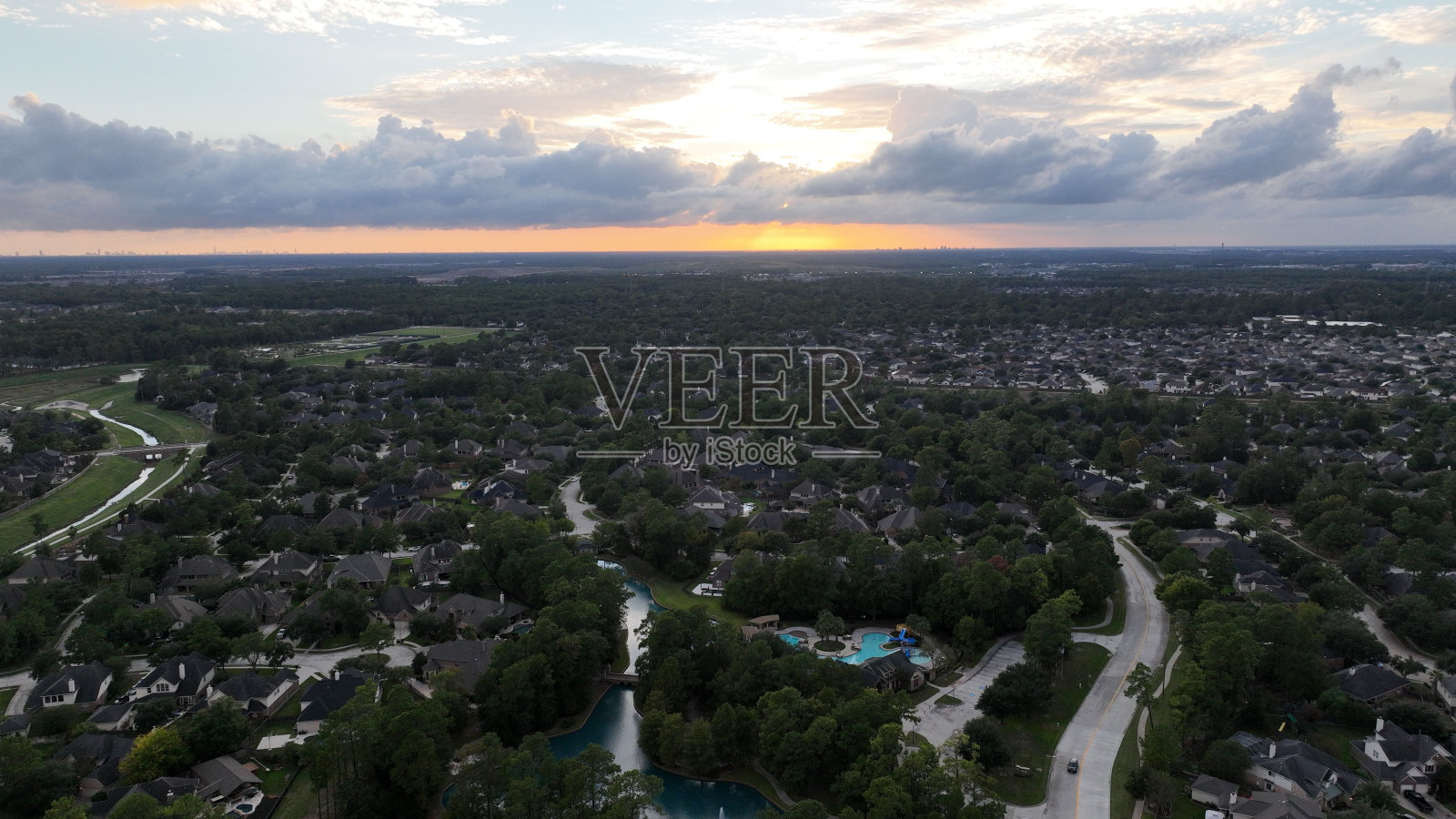 航拍照片捕捉到一个乡村,日落时道路贯穿其中照片摄影图片