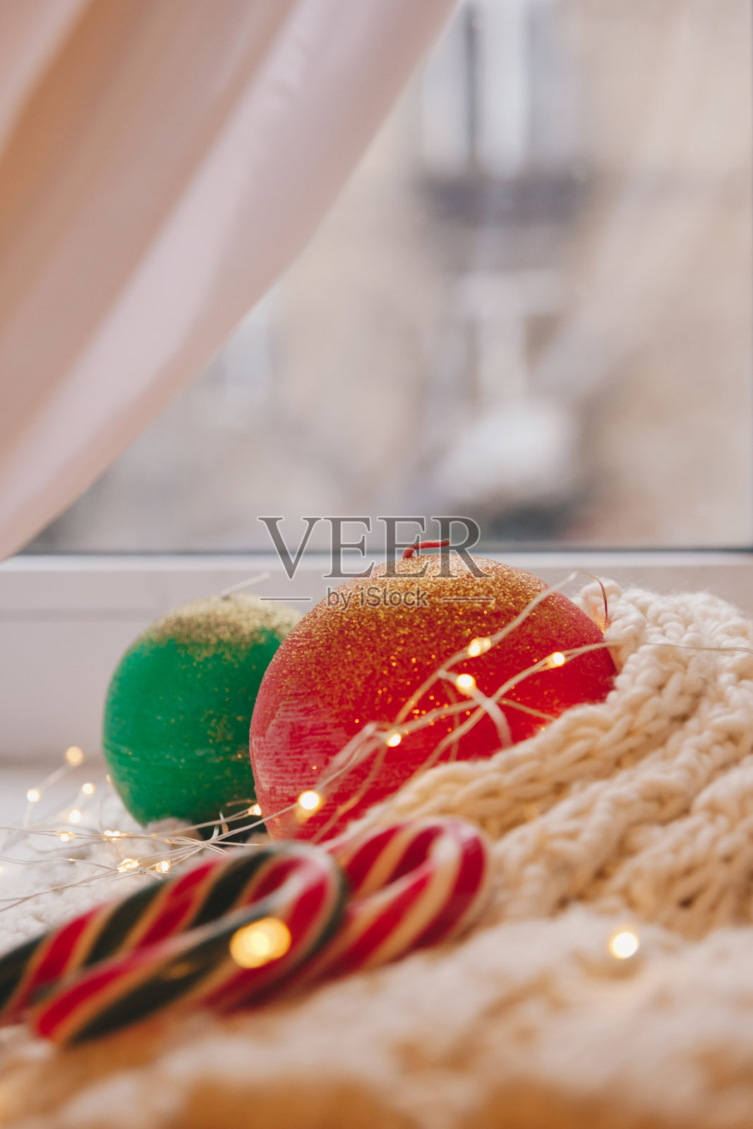 舒适的蜡烛作为球与圣诞装饰在窗台和房子为背景。新年或圣诞假期概念,节日贺卡。照片摄影图片