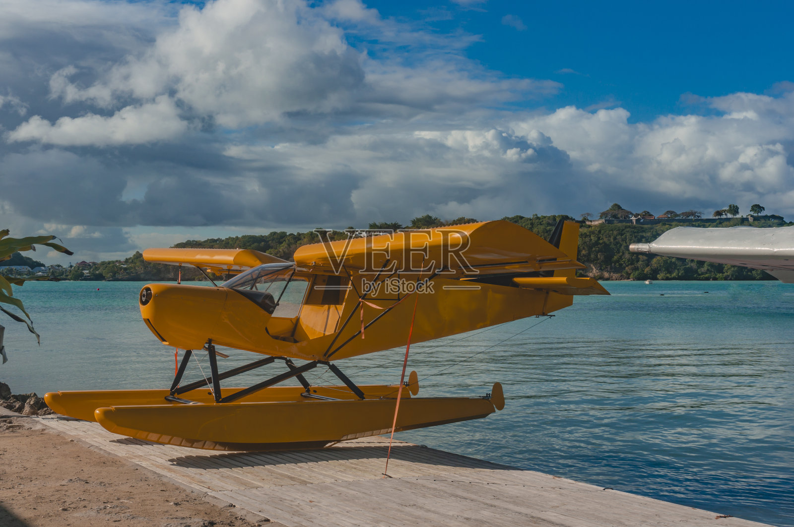 法国西印度群岛,瓜德罗普岛,戈西尔岛,多云的天空下,以大海为背景的岸边的水上飞机照片摄影图片