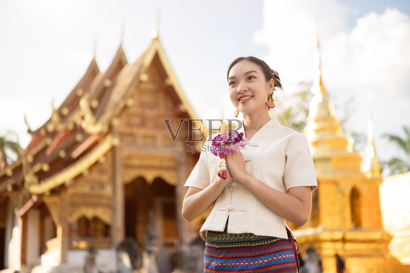 一位美丽的泰国女子穿着泰式兰娜裙,双手合十,摆出祈祷的姿势。照片摄影图片