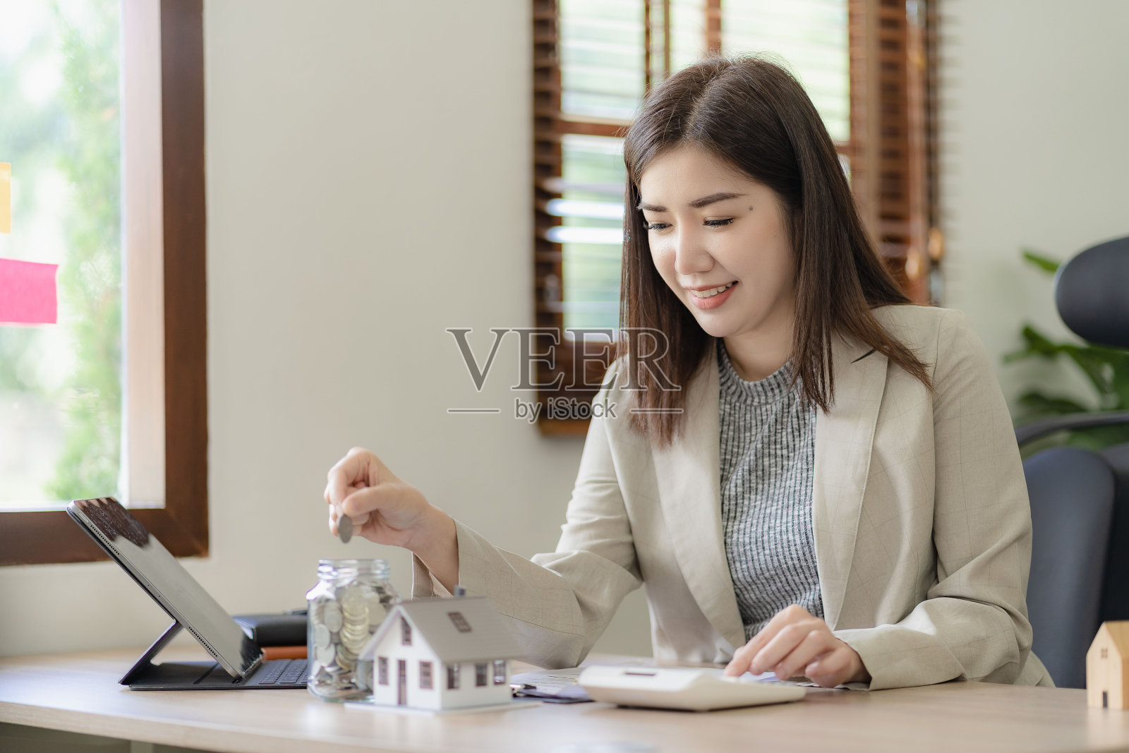 银行员工持有小白玩具屋产险、按揭、梦想搬家及房地产概念。照片摄影图片