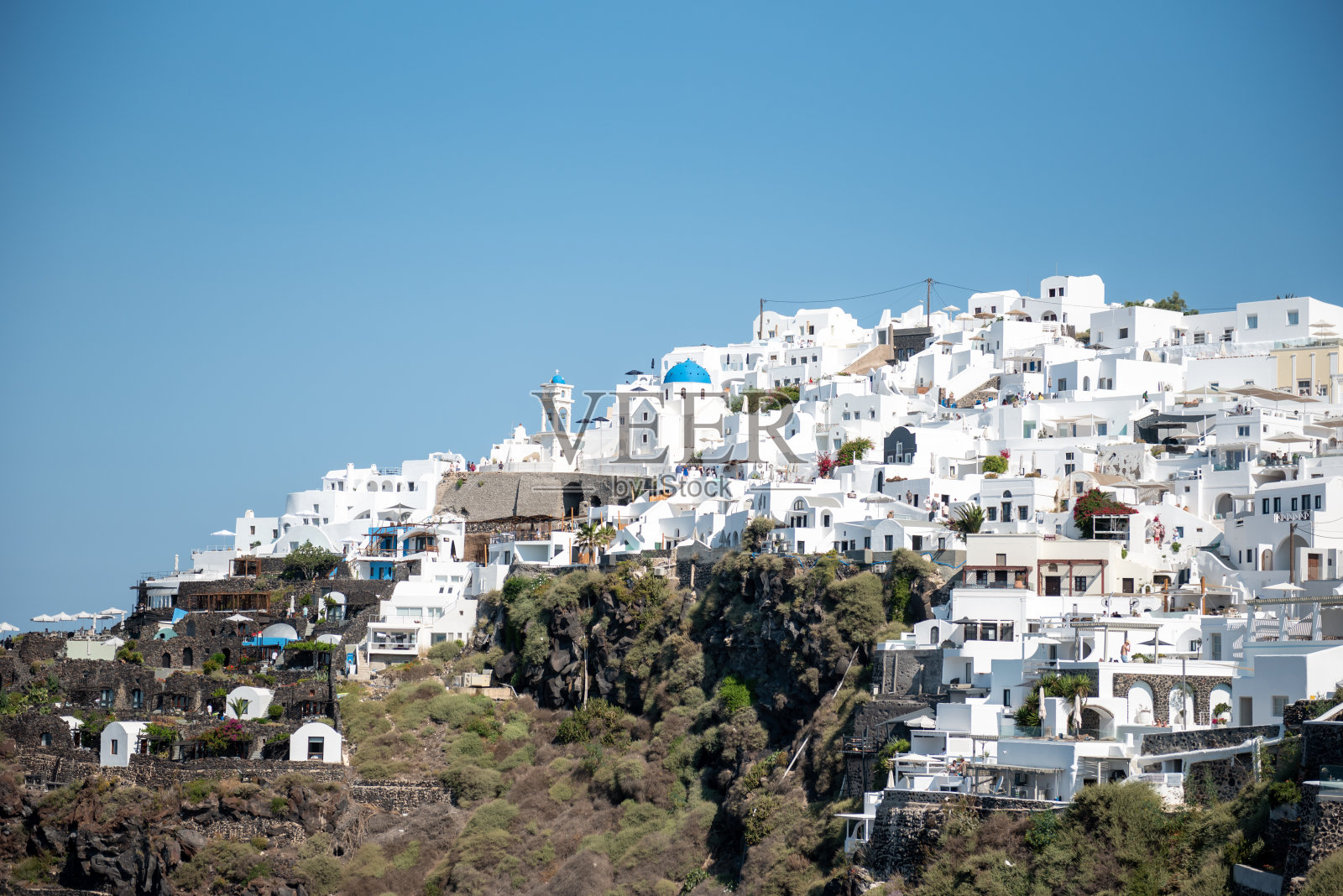 圣托里尼岛伊莫罗维里村的景色,白色的建筑,蓝色的圆顶教堂和蓝天照片摄影图片