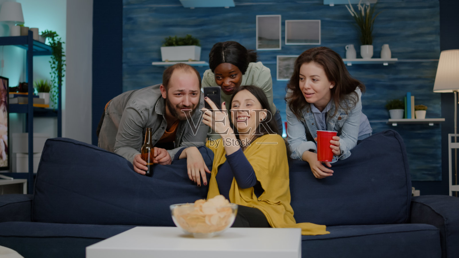 混血儿朋友们在晚上的聚会上一边看网络电影一边在客厅里放松照片摄影图片