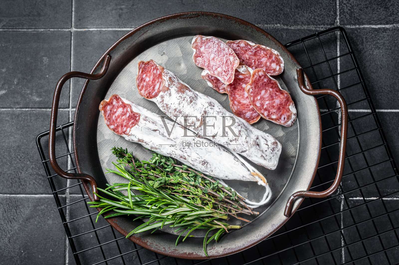 钢托盘里的香肠片。传统的西班牙香肠。黑色背景。俯视图照片摄影图片