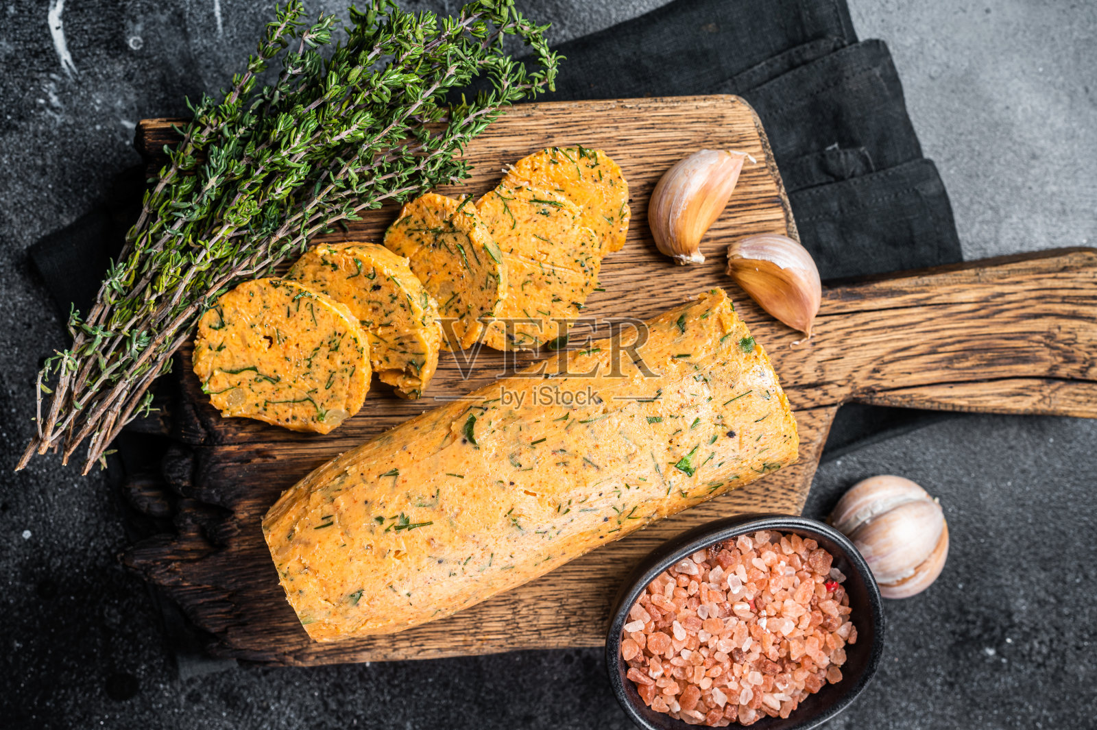 加莳萝、欧芹和大蒜的健康黄油。黑色背景。俯视图照片摄影图片