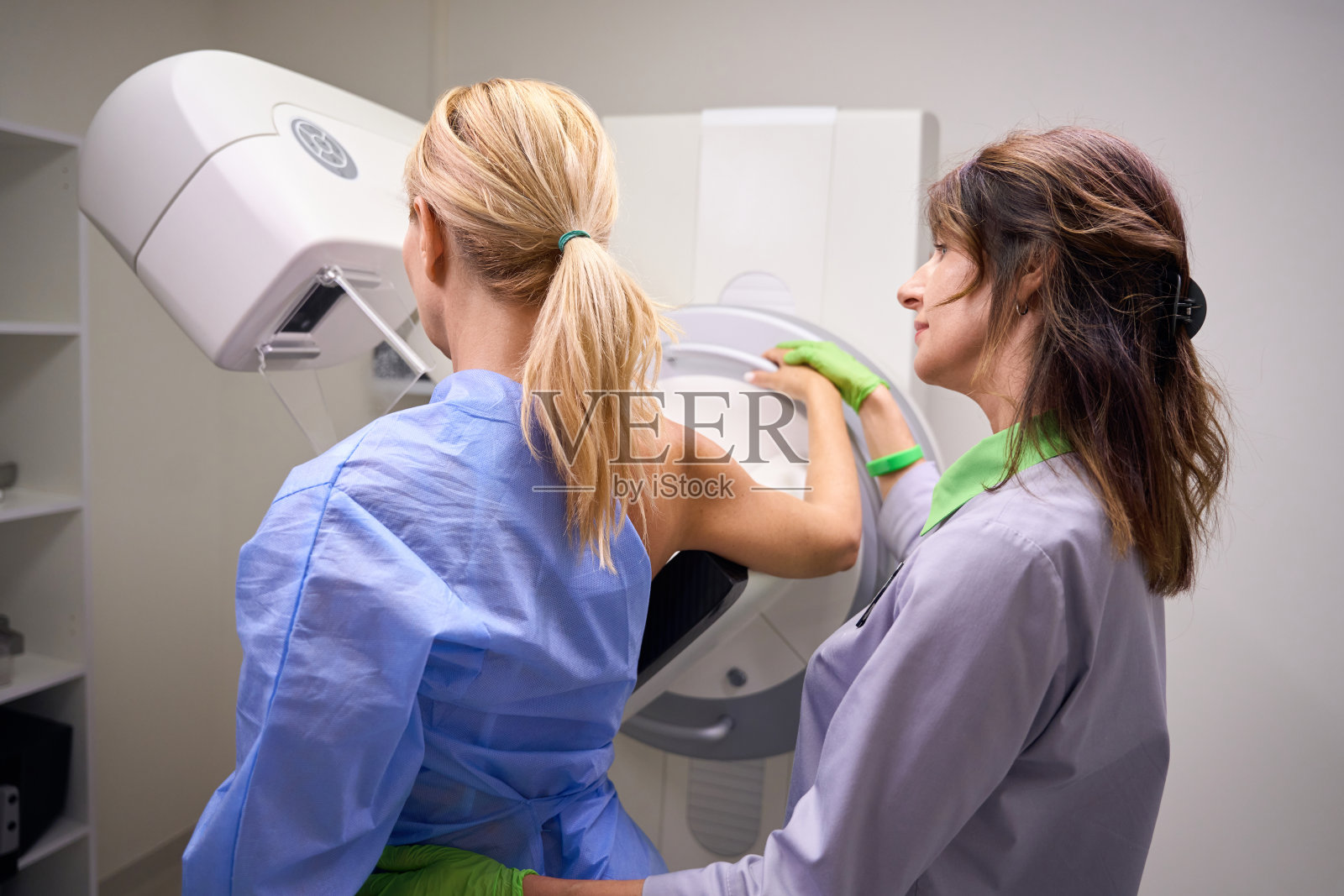 放射线技师为女性病人准备数字化乳房断层合成照片摄影图片