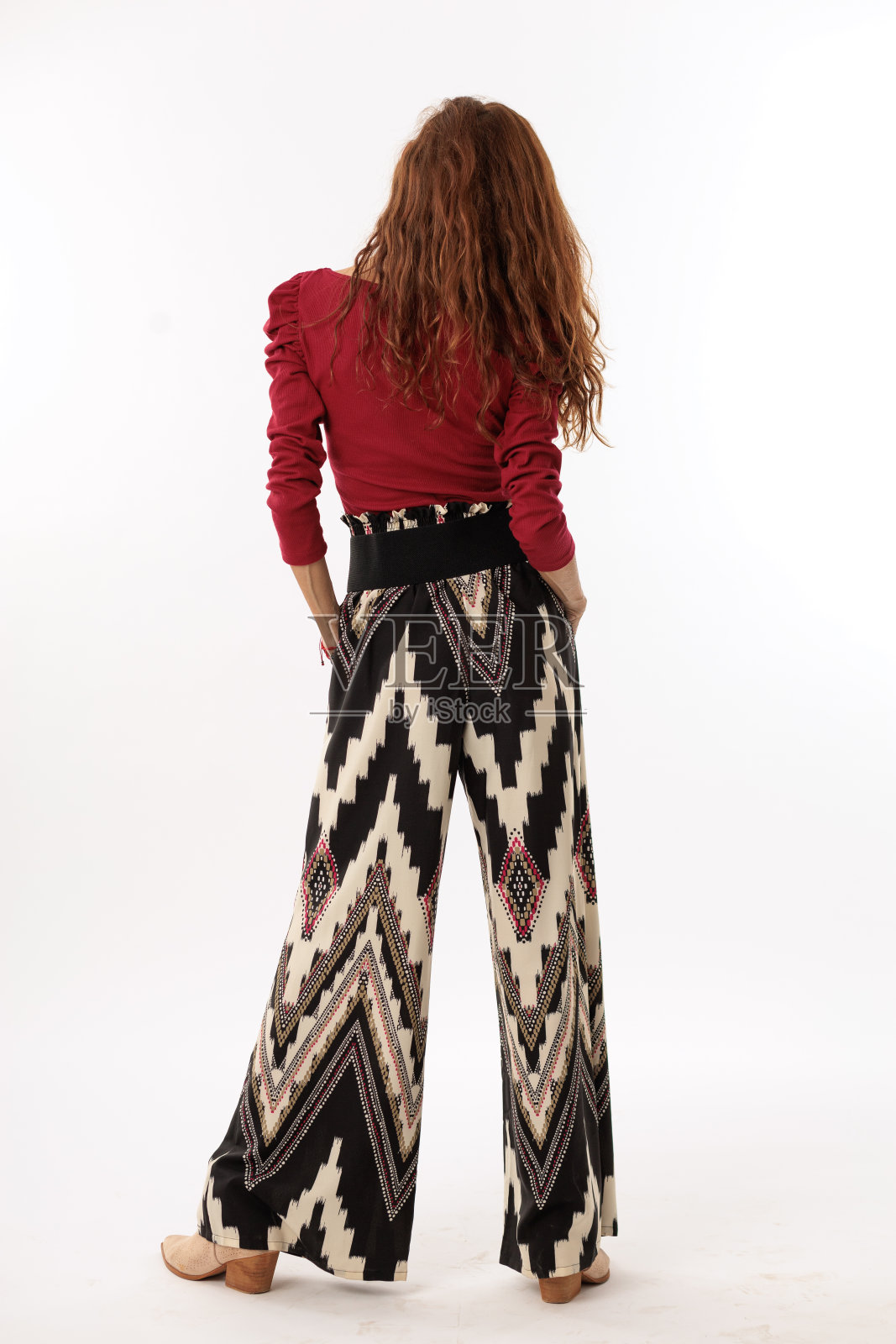 穿着白色背景的裤子和红衬衫的模特女人照片摄影图片