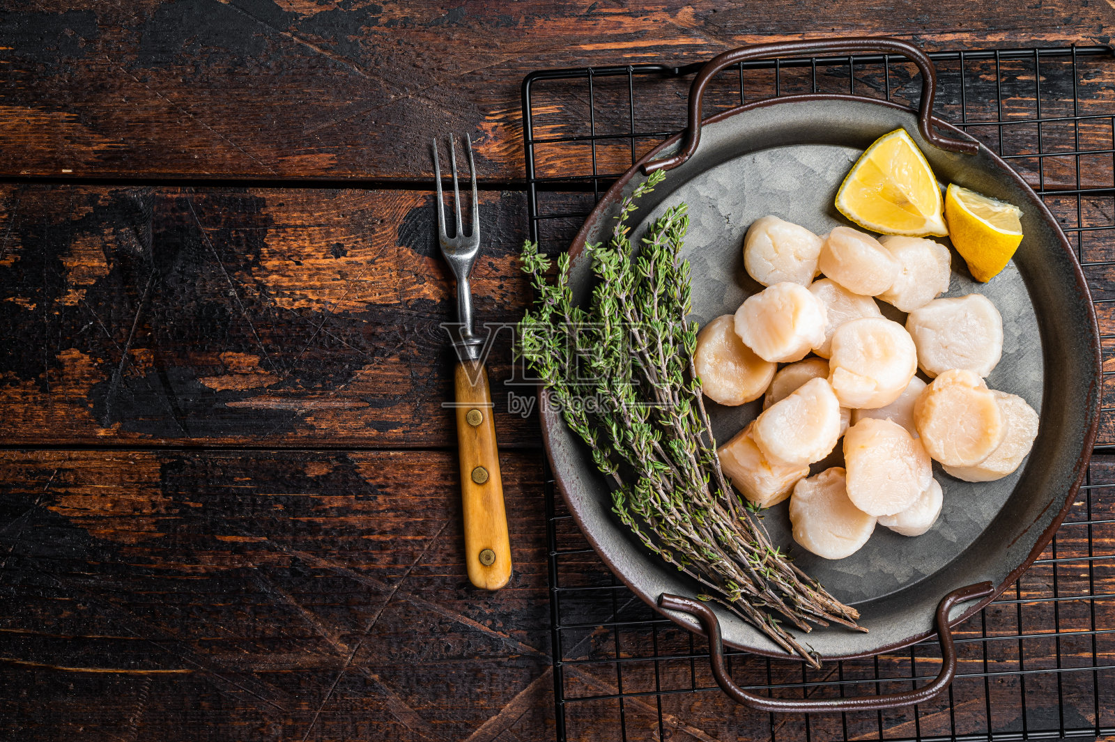 用钢盘盛着生扇贝和香草。木制背景。前视图。本空间照片摄影图片