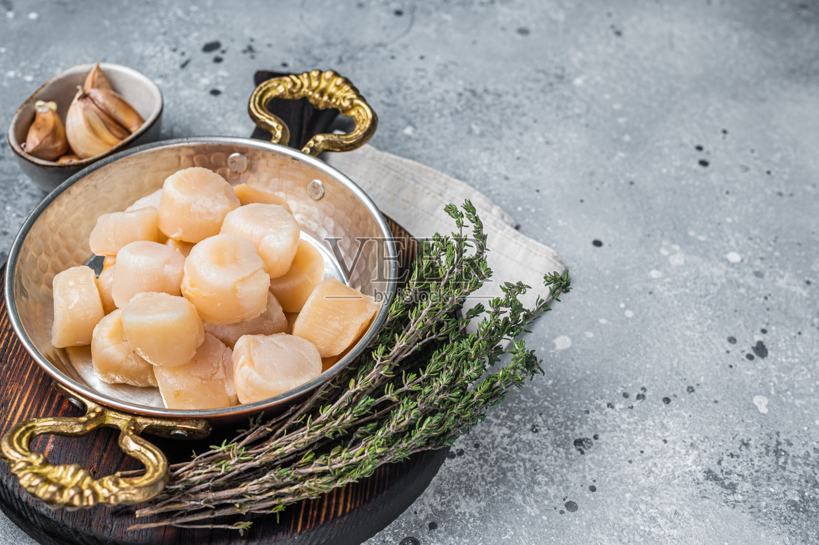 煎锅里的生海扇贝片。灰色的背景。前视图。本空间照片摄影图片