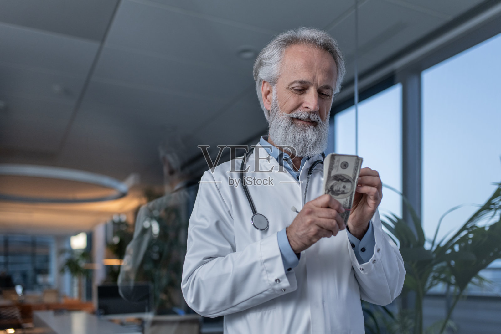 一个医生在医院的画像,手里拿着一叠钱照片摄影图片