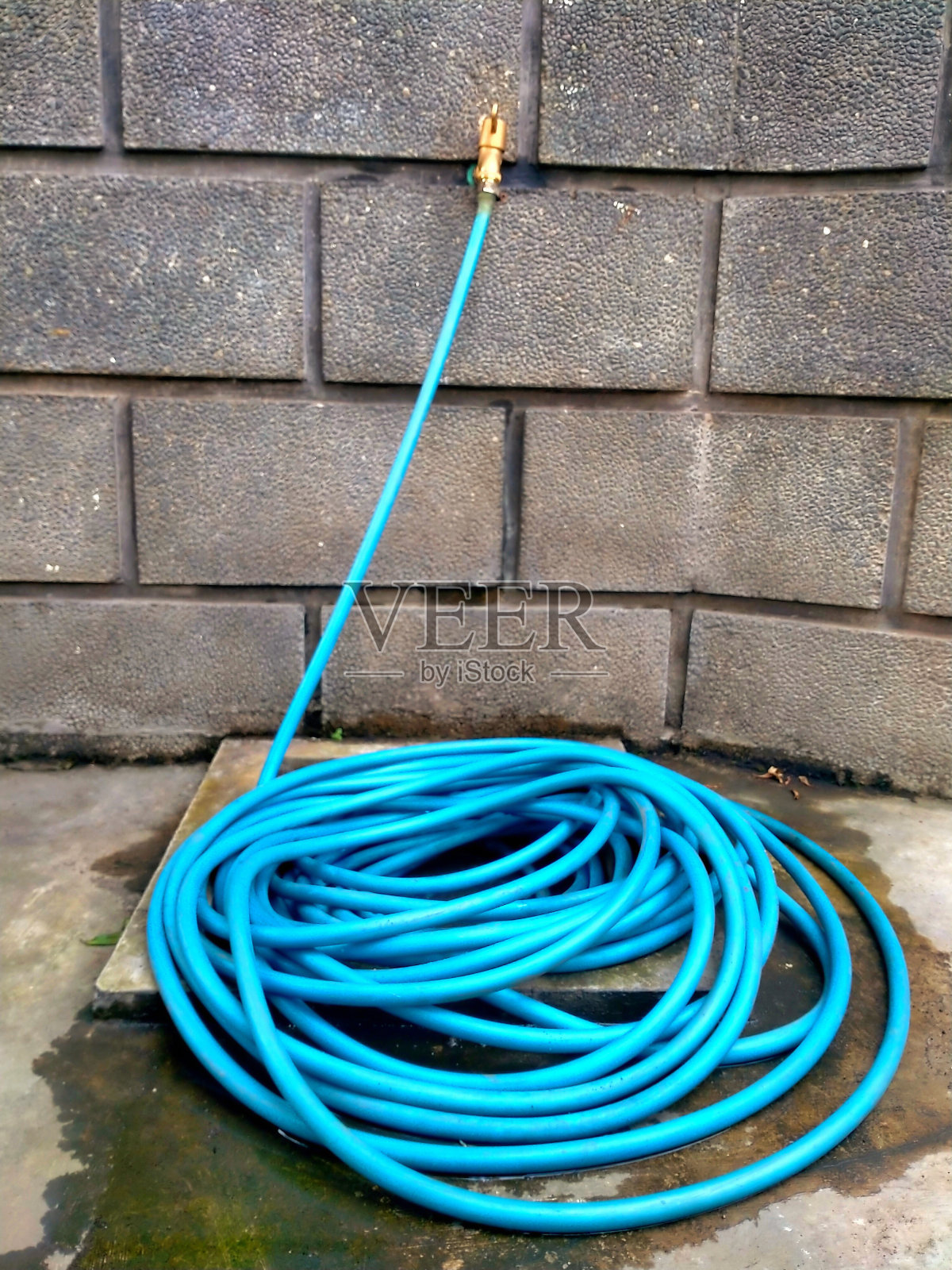 水龙头和蓝色软管盘在地板上照片摄影图片