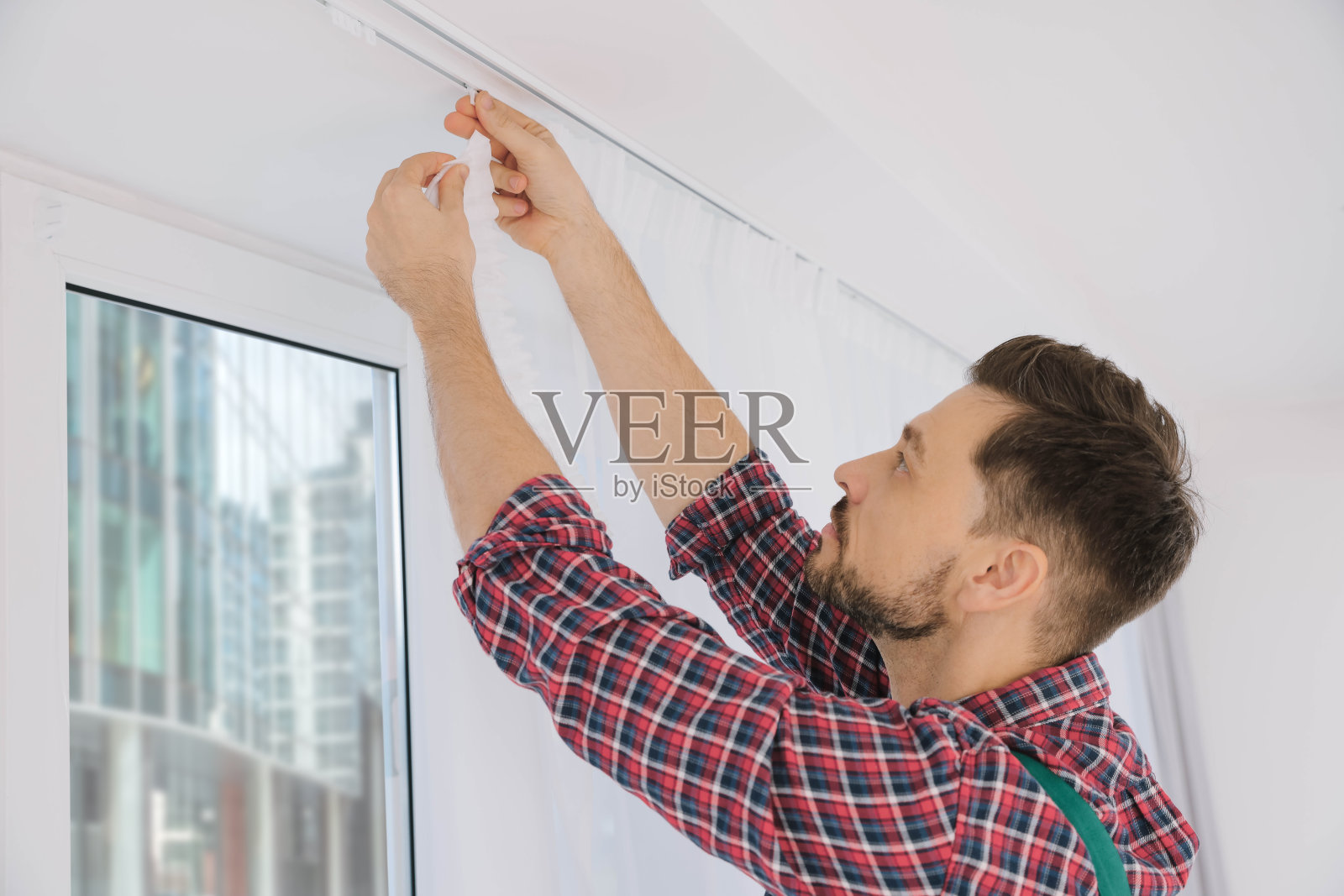 工人在室内统一悬挂窗帘,低角度观看照片摄影图片