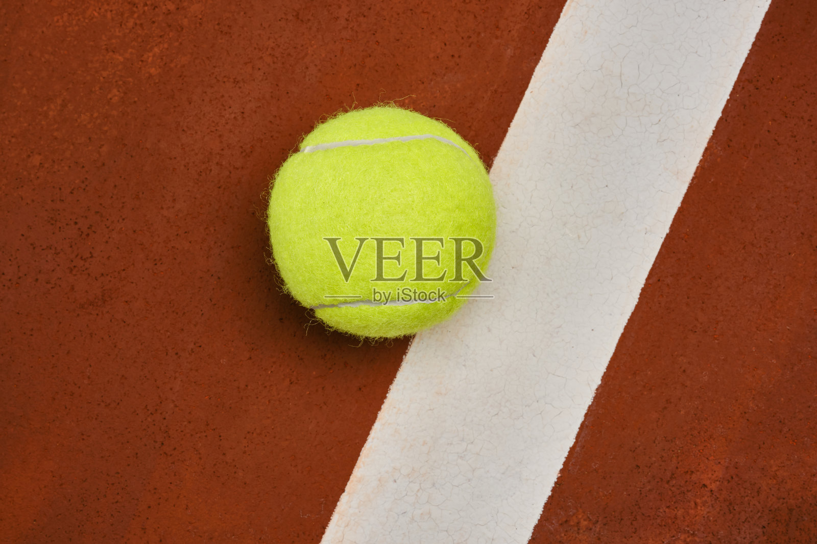 有白色条纹的橘黄色场地上的网球照片摄影图片