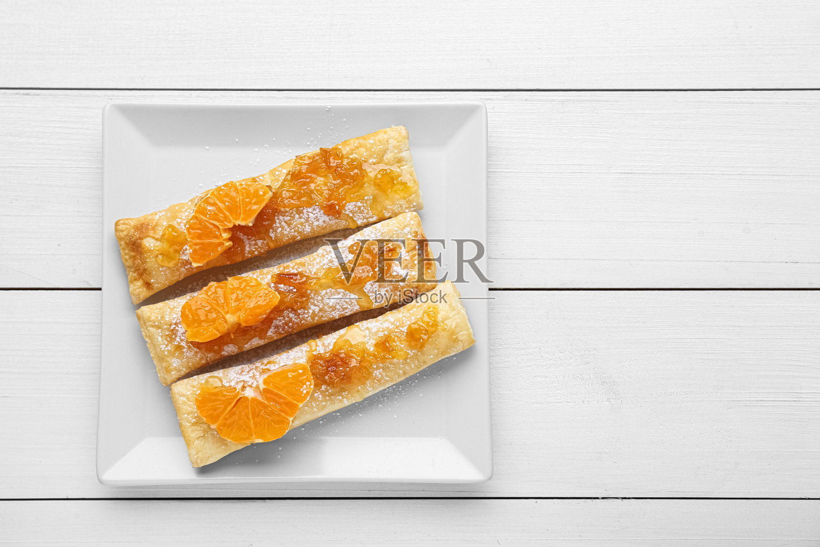 白色木桌上新鲜可口的糖粉蜜橘酥皮,俯视图。文本空间照片摄影图片