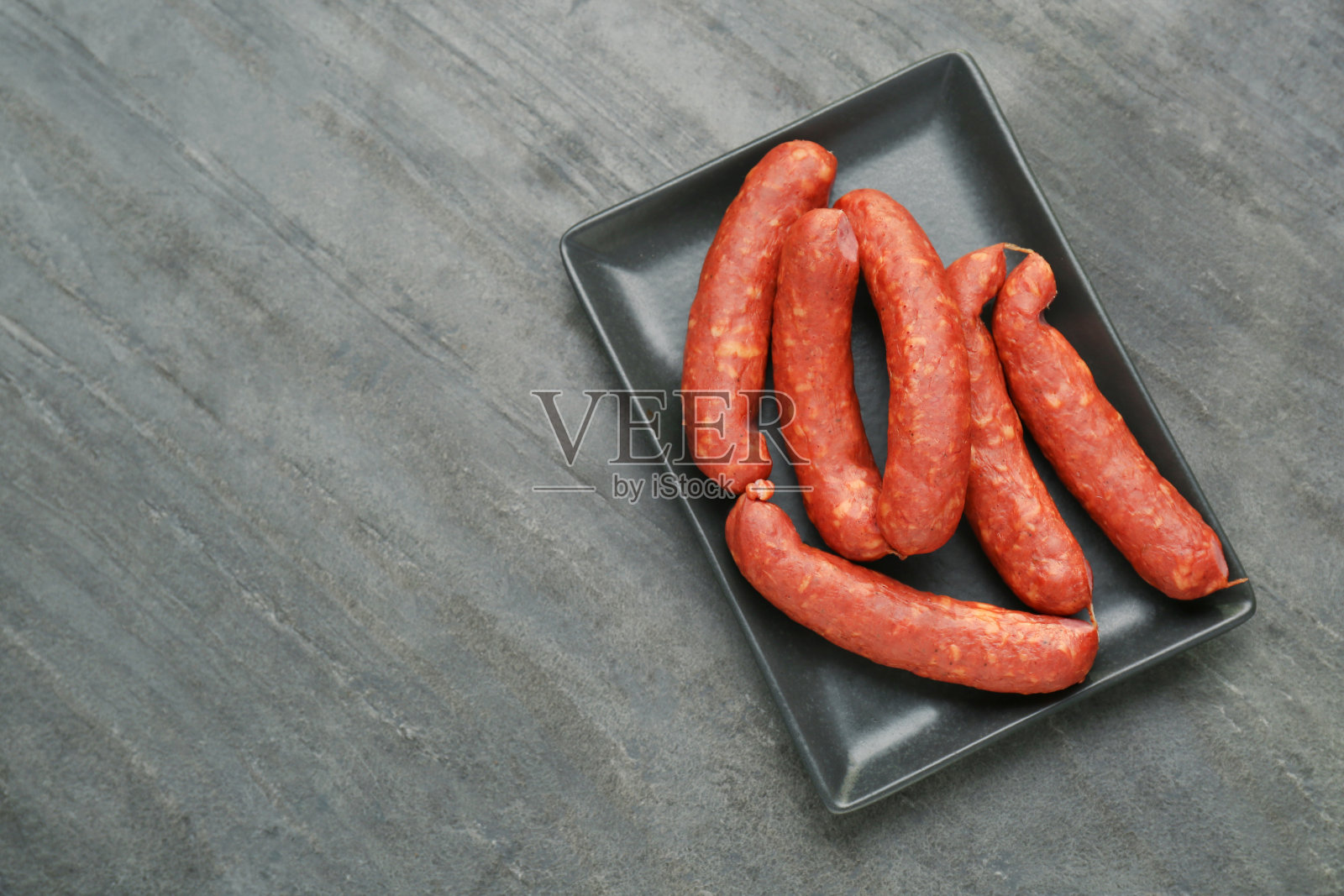 美味的香肠盘在黑色的桌子上,俯视图与文字的空间。肉类产品。照片摄影图片