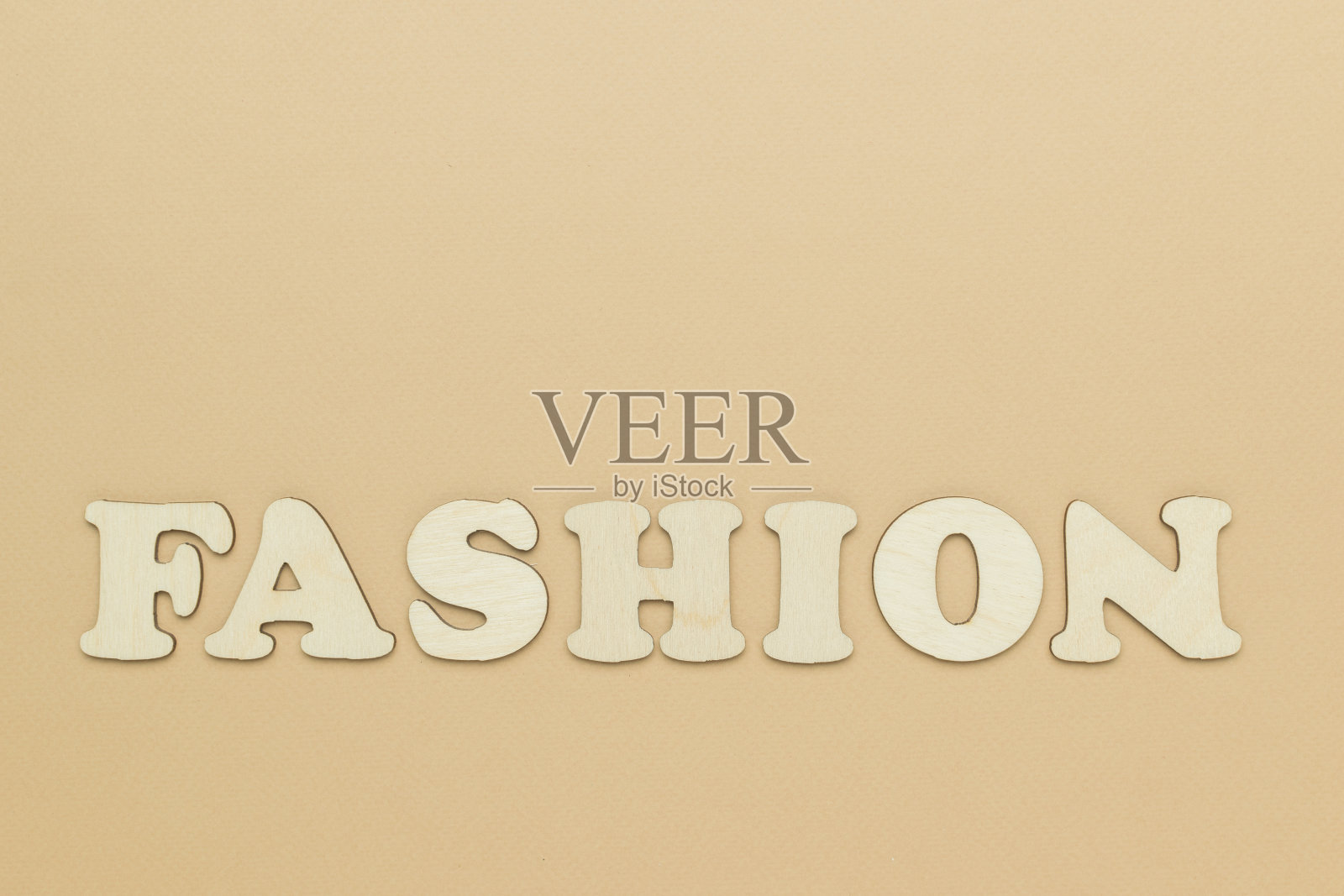 时尚铭文是米色背景上的木制字母。照片摄影图片