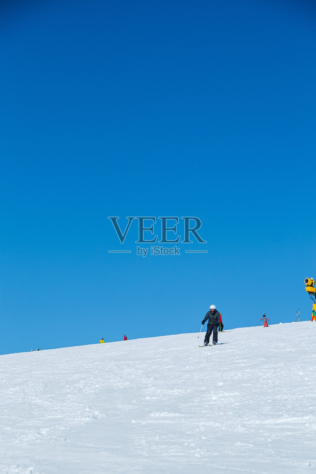 滑雪者从覆盖着皑皑白雪的坡顶出发,滑雪季节来临照片摄影图片