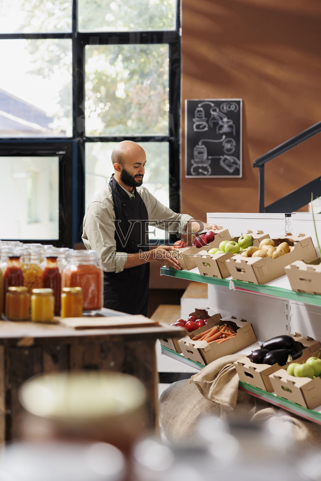 小贩把一盒红苹果放在架子上照片摄影图片