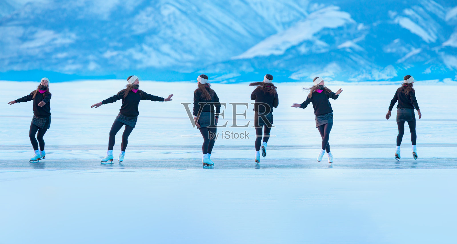 在一个阳光明媚的冬日,一位快乐的年轻女子在贝加尔湖透明的冰面上滑冰照片摄影图片
