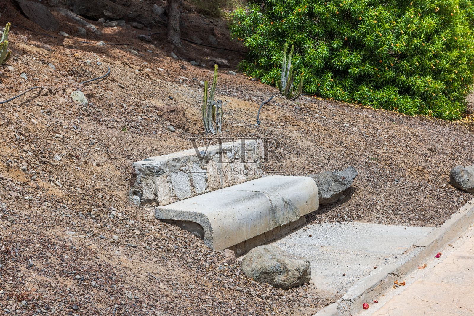 沿着小径的石凳特写,背景是热带植物的山脉。西班牙的大加那利岛。照片摄影图片