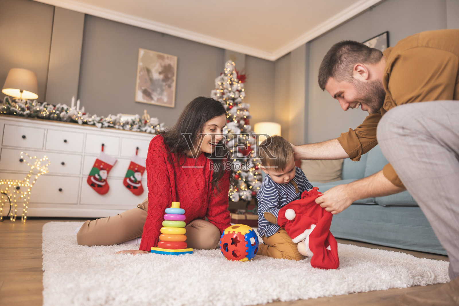 孩子在家里和父母一起拆圣诞礼物照片摄影图片