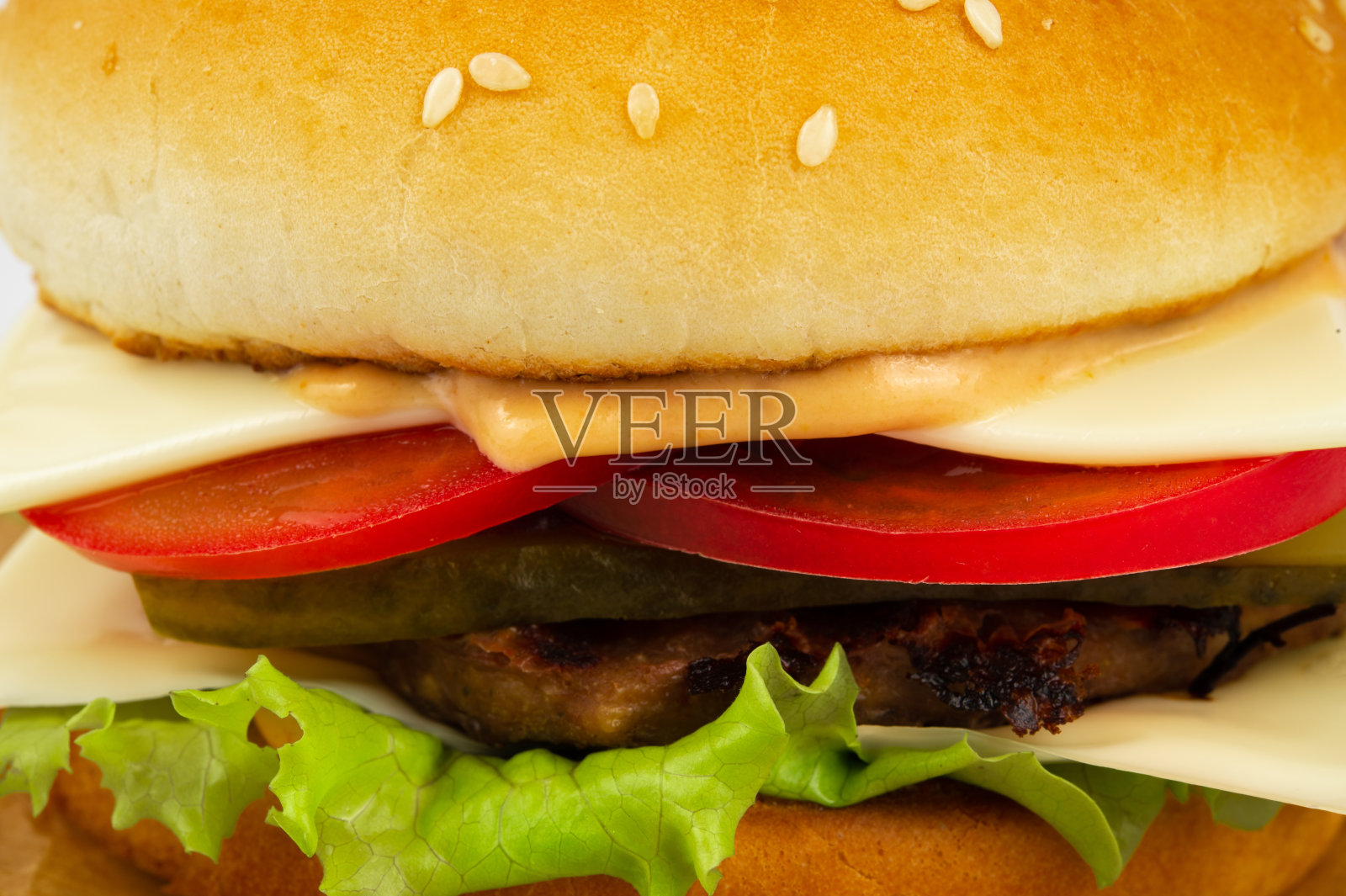 汉堡配牛肉饼、西红柿、奶酪、蔬菜沙拉和泡菜照片摄影图片